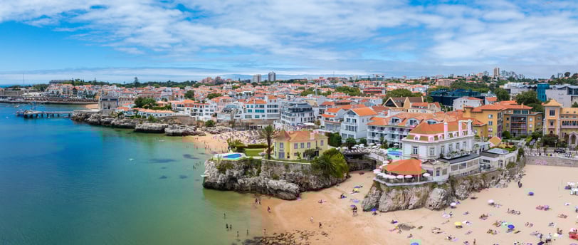 Drone aerial view of Praia da Rainha and historic city centre of Cascais, Portugal