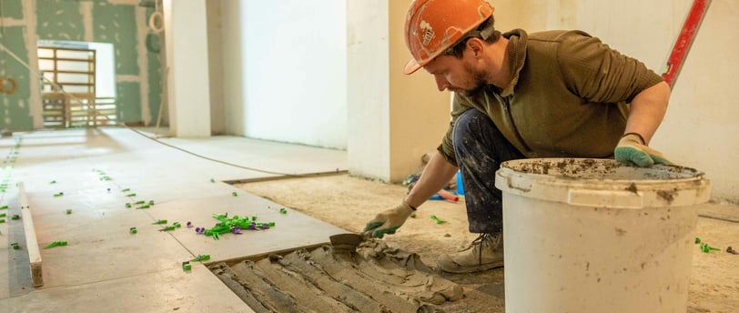 this image displays a man installing tiles and saving the labor cost.