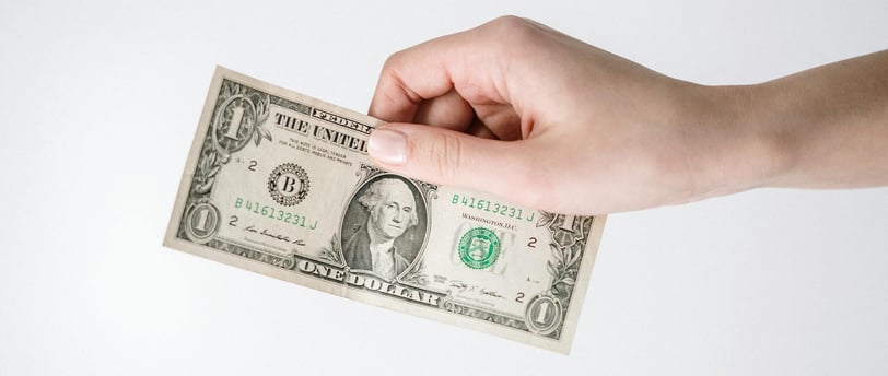 a dollar bill being held for dollar cost averaging