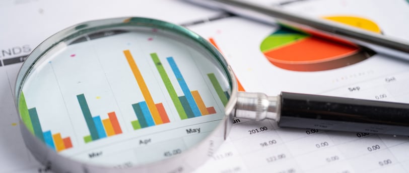 magnifying glass looking at statistics and values