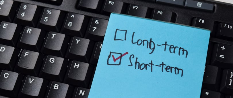post it note with short term box checked and a keyboard