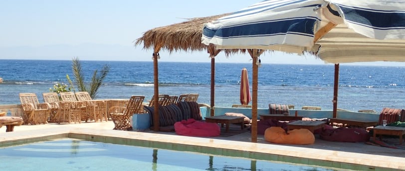 bazen na plaži sa suncobranima i ležaljkama