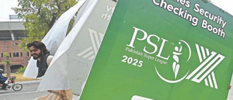 Man carrying a dismantled PSL 2025 ladies security booth on a street in Lahore.