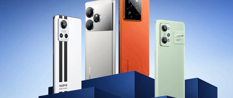 A lineup of Realme smartphones in various colors including white, silver, orange, and green, display