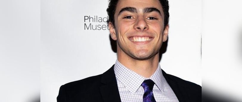 a man in a suit and tie smiling