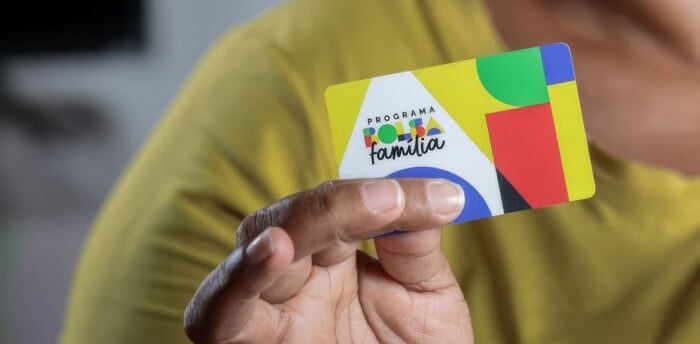 uma pessoa segurando o cartão do bolsa família.