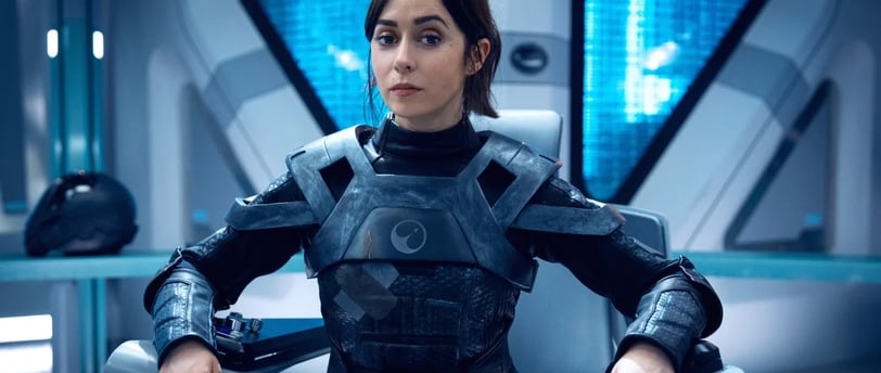 Woman in metallic futuristic armor in high-tech setting from Black Mirror series.