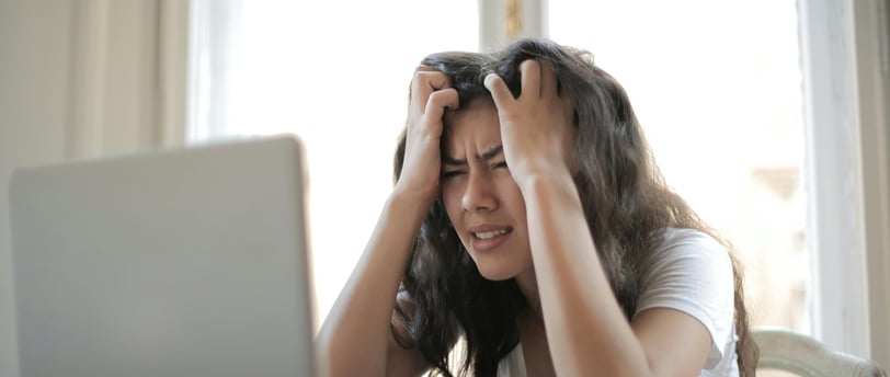 a woman sitting at a table with a laptop computer