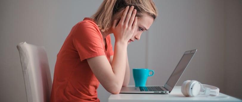 a woman sitting at a desk with a laptop computer