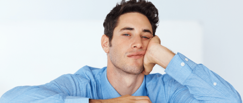 a man sitting at a table with his hand on his chin totally bored