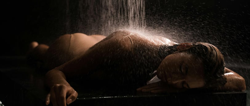 a woman in a bikini top is taking a shower