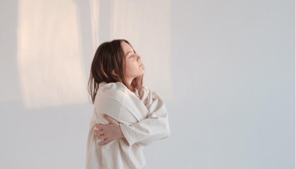 a girl folding her hands around her body