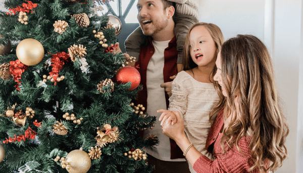 Christmas tree beside a family members standing