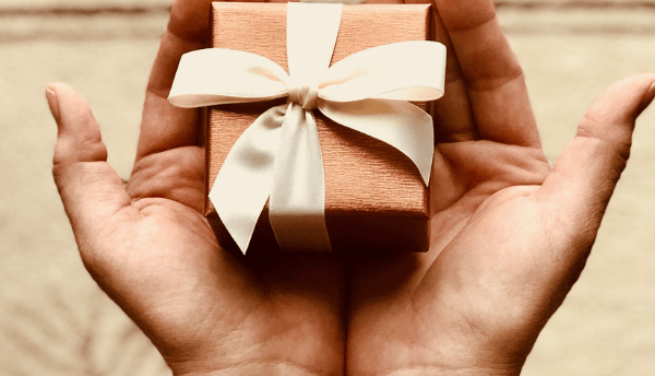 holding a small gift box in both hands