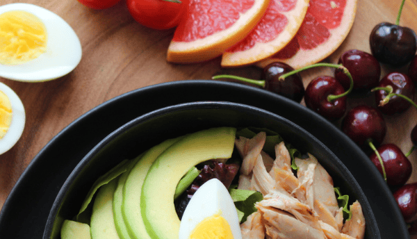 a bowl of fresh vegetables and fruits on table