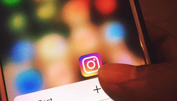 holding a phone which has Instagram logo