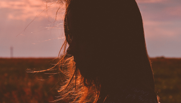 a girl standing in sunset 