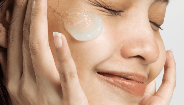 a girl smiling and moisturize is on her face