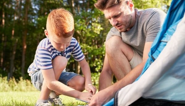 padre e hijo montando una tienda de campaña