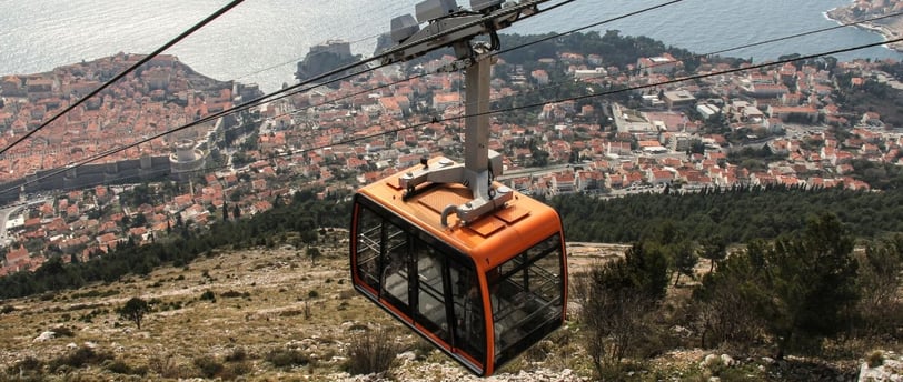 Teleférico em Dubrovnik com vista do alto para o mar.