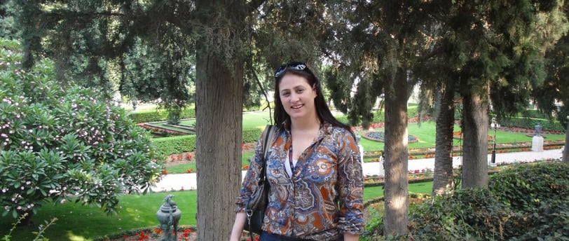 Foto da autora nos jardins em Haifa.
