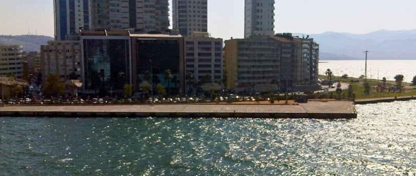 Vista do navio para a cidade de Izmir ao chegar no porto, mostrando a costa e o skyline urbano.