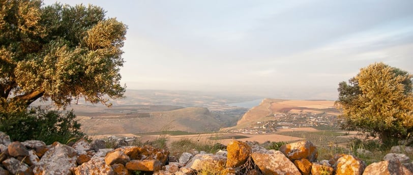 Vista panorâmica da Galileia com suas colinas e campos extensos ao entardecer.