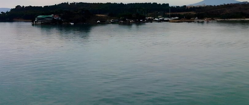 Foto tirada do convés mostrando a cidade de Vólos ao amanhecer, na chegada de navio.