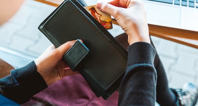 A person taking a credit card out of wallet.