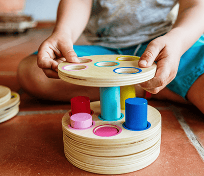 a child's hands holding a wooden toy