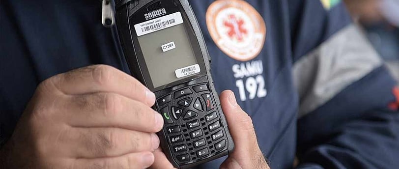 Um profissional do SAMU segurando um rádio