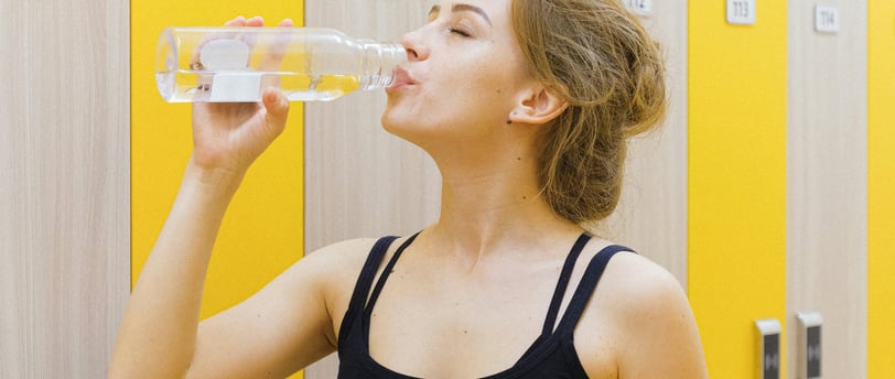 A woman drinking warm water to stay hydrated during the winter season, promoting healthy hydration 