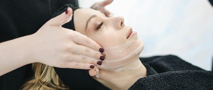 A woman applying natural honey and lemon face mask, promoting clear skin with DIY skincare solution