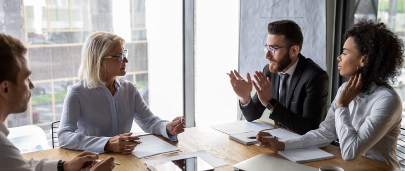 A team of legal professionals discussing fractional executive solutions for law firm management.