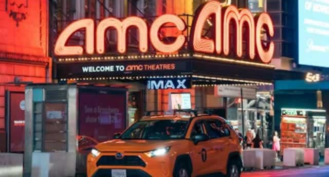 AMC entertainment holdings inc logo on top of theatre with orange taxi cab parked in front