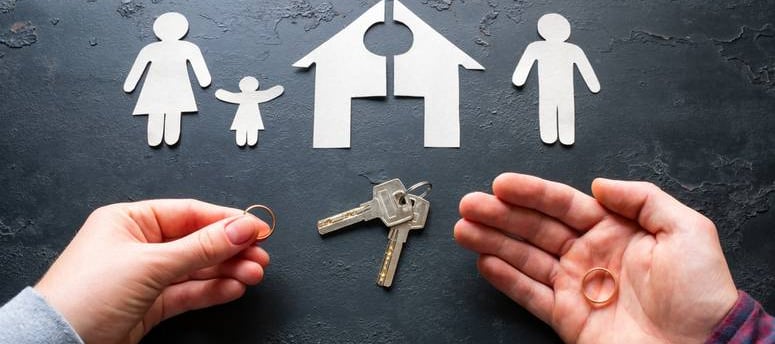 a person holding a keychaik and a house shaped paper cutout of a