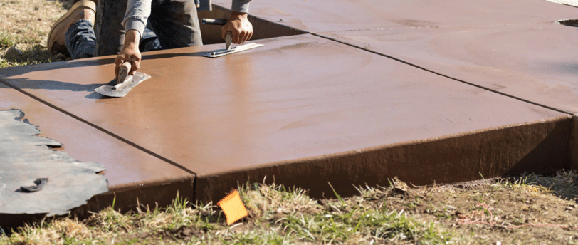 a man is using a knife to cut a concrete slab