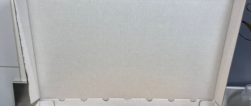 a pizza box with cheese and sausages