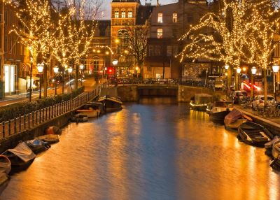 Amsterdam - a river with boats and christmas lights on it