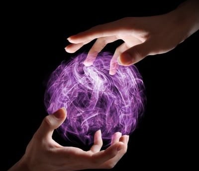 magic - two hands holding a purple ball with a purple ball