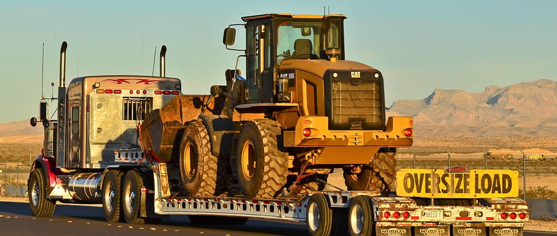 a tractor trailer with oversize load banner