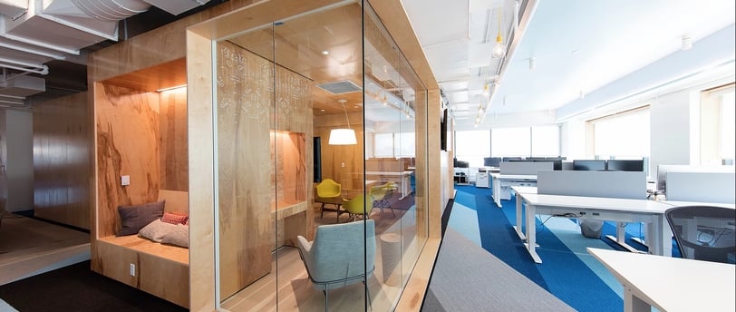 a glass walled office space with a couch and a chair in Dubai