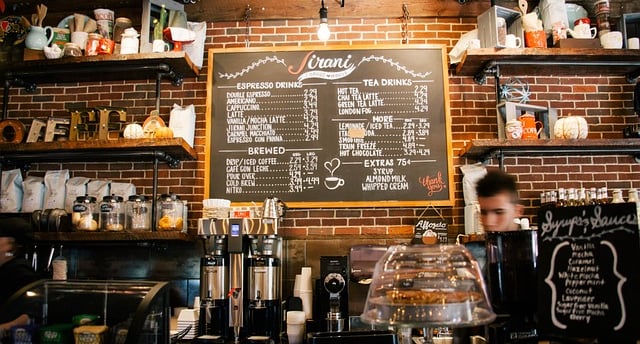 a man is standing in front of a chalkboard with a menu on it