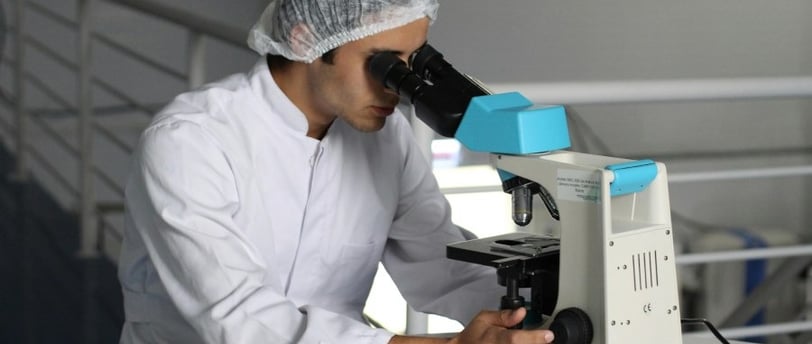 Pesquisador usando microscópio em laboratório de curso gratuito