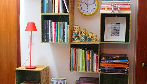 a bookshelf with books, decorations and a lamp 