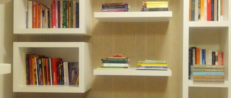 a room with a book shelf and a lamp