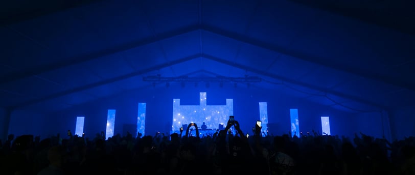 Congregation worshiping with vibrant visuals displaying worship lyrics and scripture on large screen