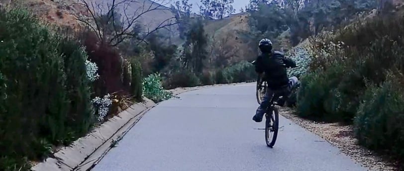 Mountain bike rider practicing manual and wheelie techniques for skill building