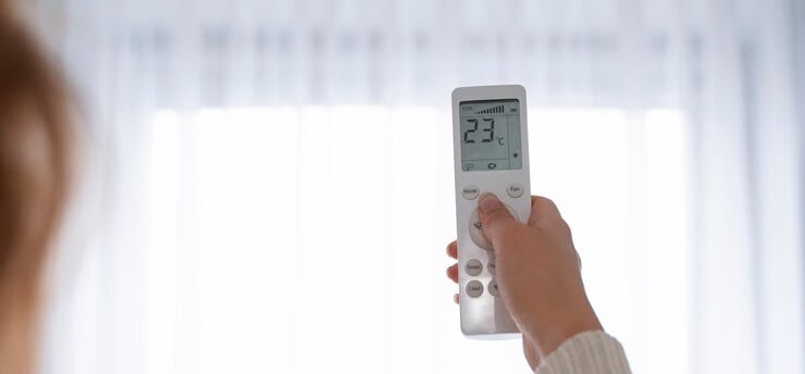 Femme à Rennes qui utilise sa climatisation avant été chaud en Bretagne