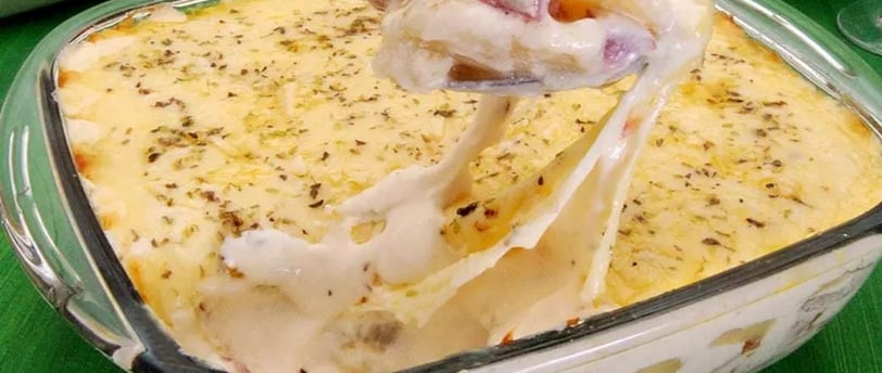 Imagem-de-um-refratário-de-cerâmica-com-batata-gratinada-quente-e-cremosa. A batata está cortada em 